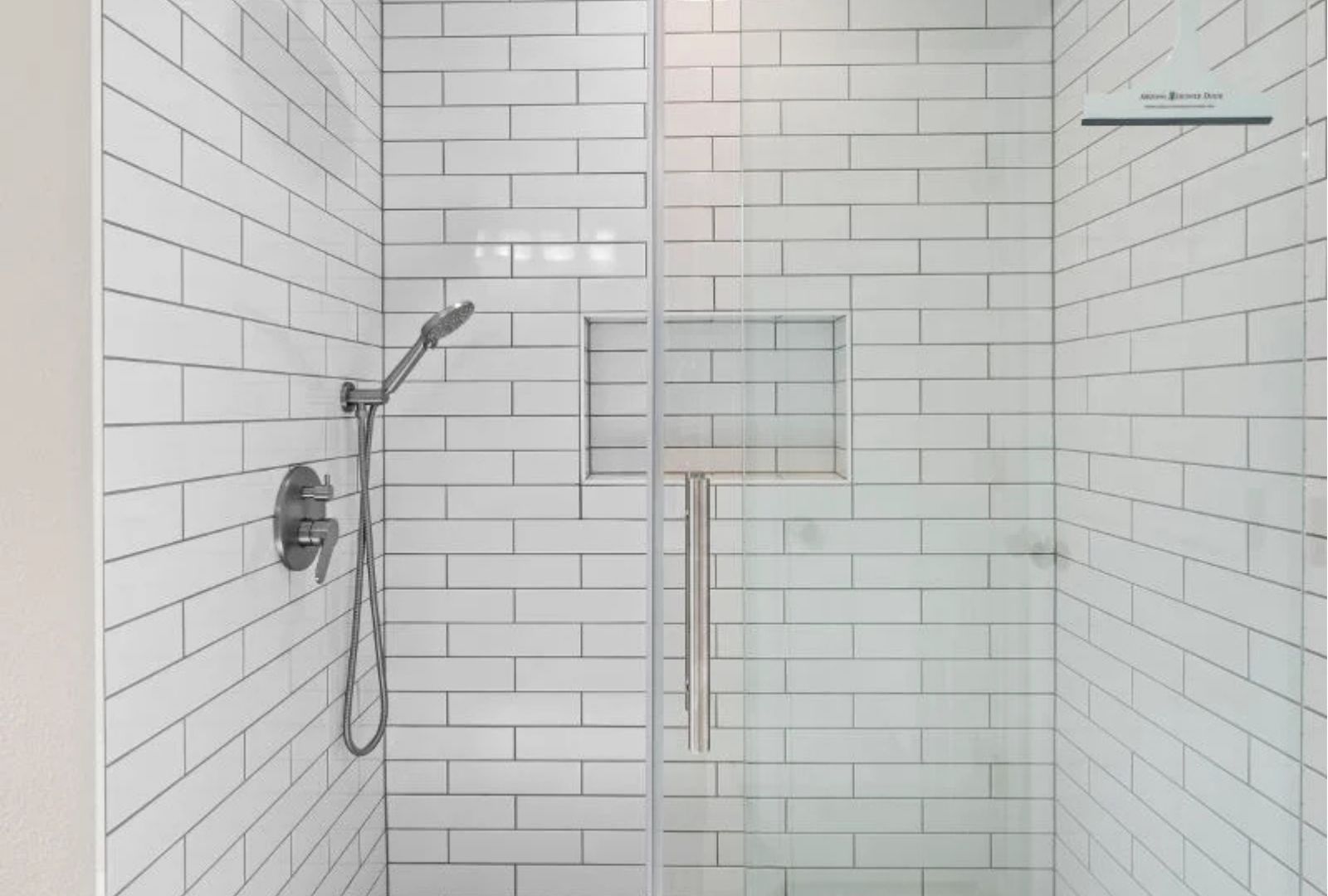 Shower valve and handheld shower installed on a tiled wall