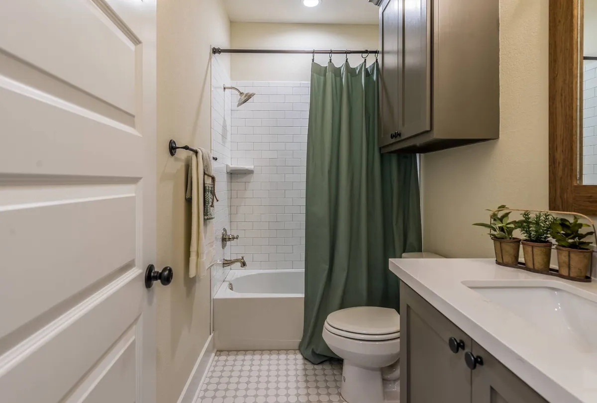 Green shower curtain in newly built bathroom
