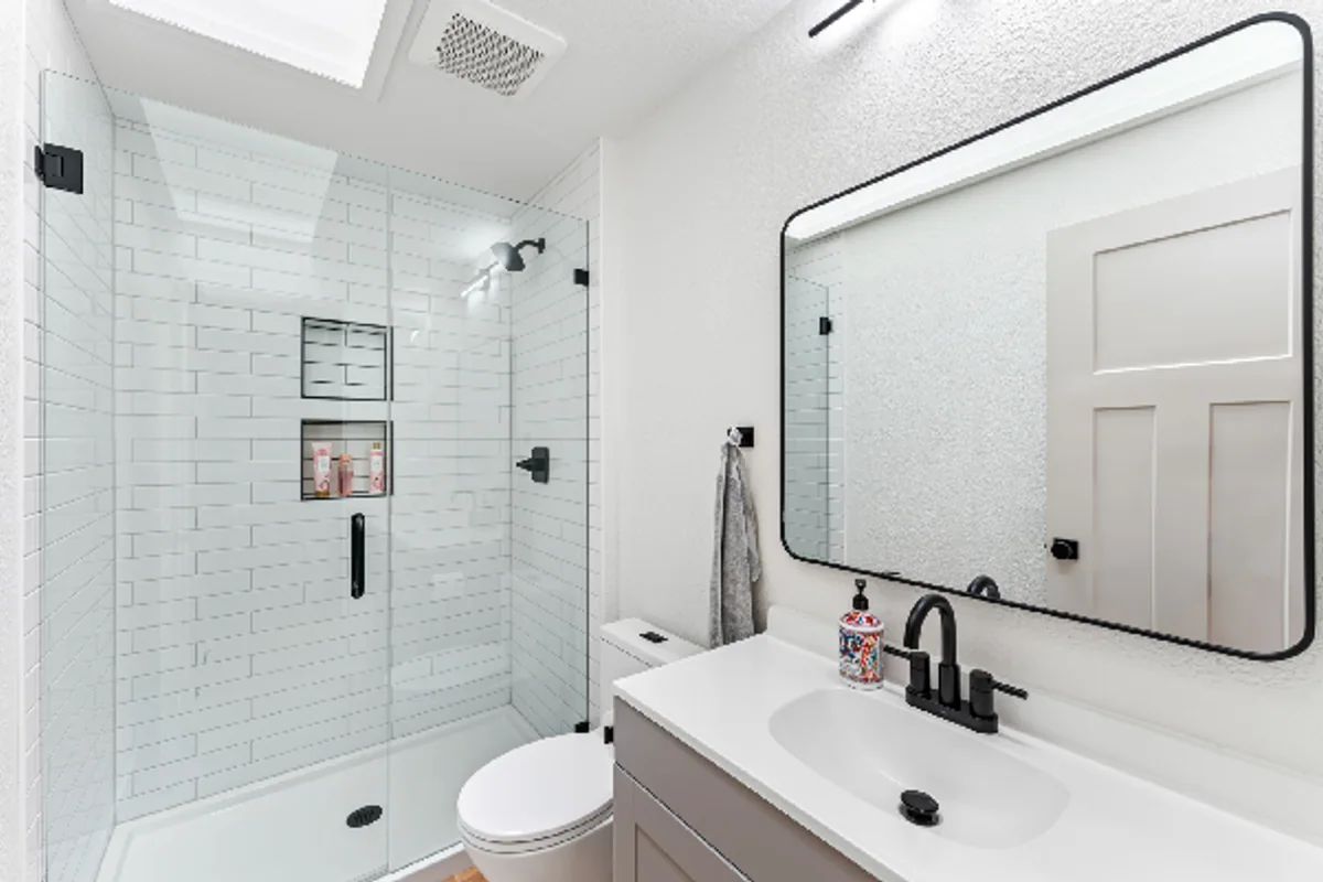 New bathroom vanity beside a tiled walk-in shower
